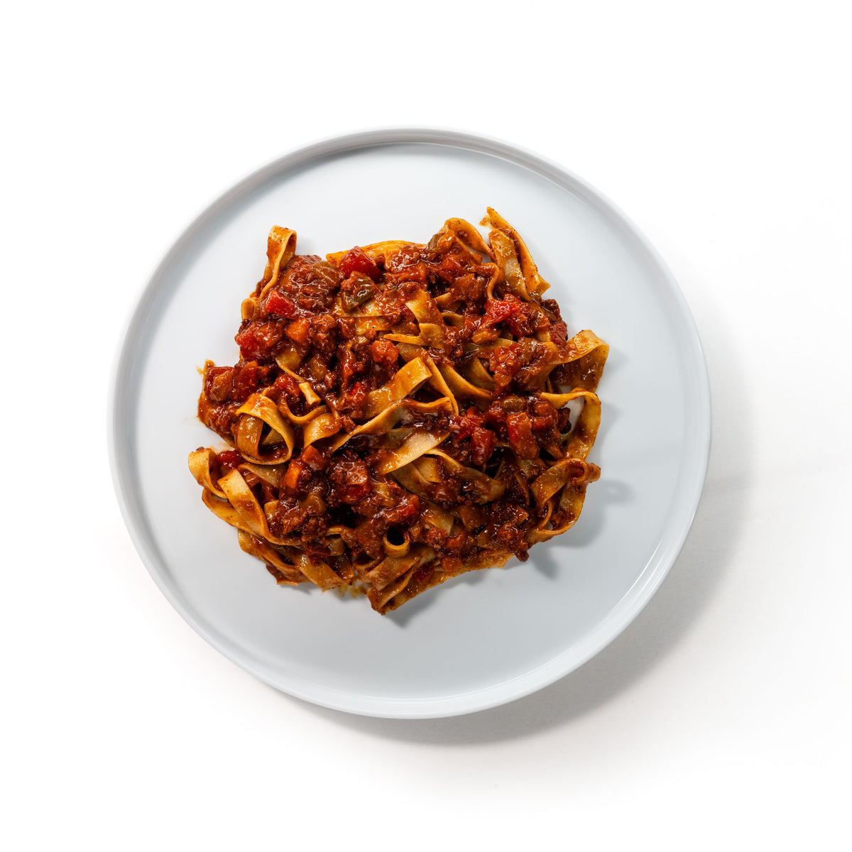 Teller mit breiten Bandnudeln und Bolognese von oben