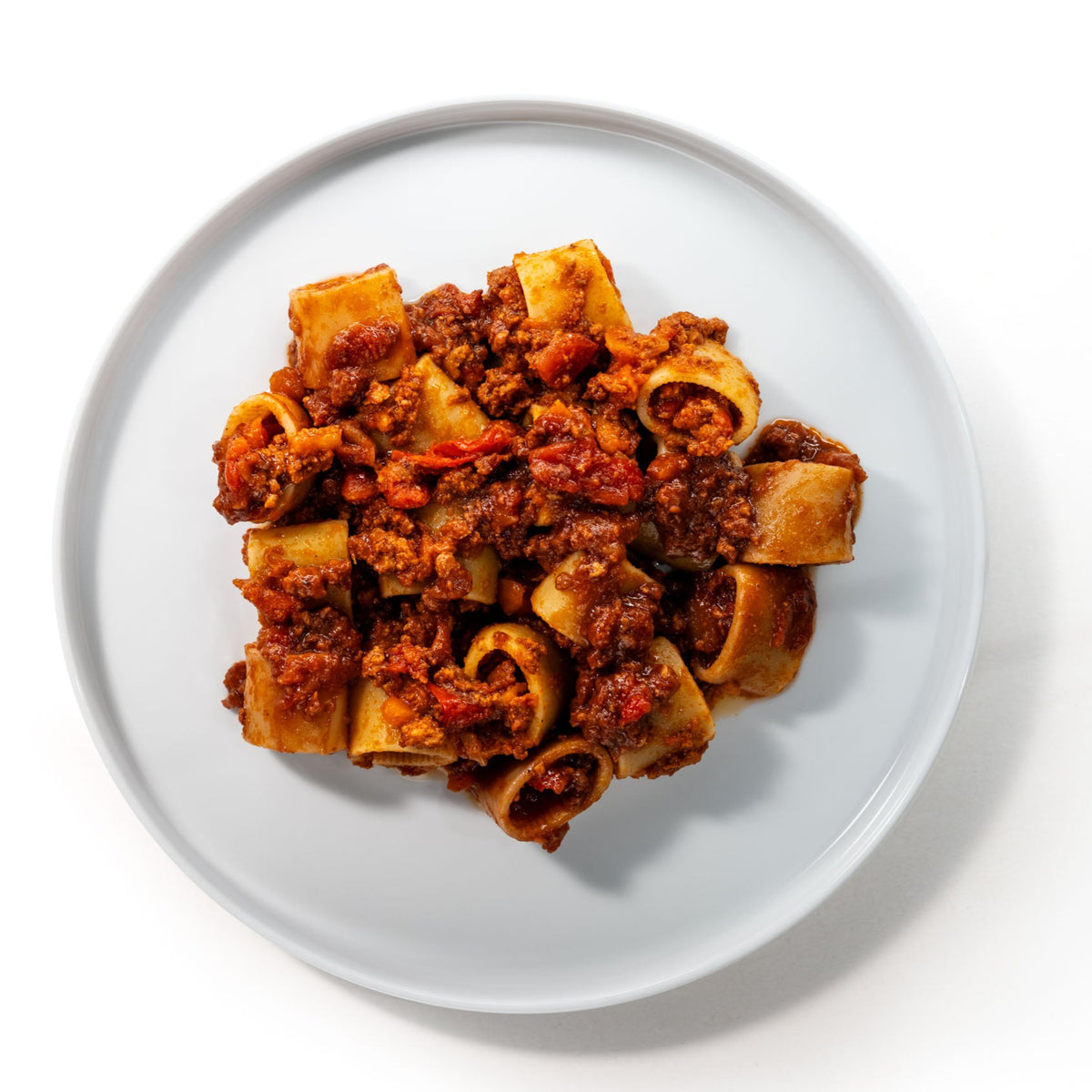 Bord met korte buisvormige pasta en Bolognese Salsiccia, van bovenaf gezien